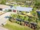 Aerial view of a well-maintained yellow house with metal roof and mature landscaping at 9031 Hilolo Ln, Venice, FL 34293