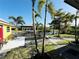 Lush backyard with mature landscaping, palm trees, and waterfront views at 9031 Hilolo Ln, Venice, FL 34293