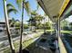 Scenic backyard view with tropical trees, waterfront access, and a well-maintained lawn at 9031 Hilolo Ln, Venice, FL 34293