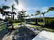 Landscaped backyard with trees, green grass and a view of the home's exterior at 9031 Hilolo Ln, Venice, FL 34293
