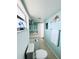 Compact bathroom with a single sink, toilet, and stylish seashell-themed decor at 9031 Hilolo Ln, Venice, FL 34293