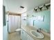 Well-lit bathroom with a wide mirror, single sink, vanity storage, and a shower/tub combination at 9031 Hilolo Ln, Venice, FL 34293