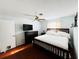 Comfortable bedroom featuring a ceiling fan, black dresser and queen-sized bed with white linens at 9031 Hilolo Ln, Venice, FL 34293