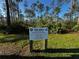 Signage indicating 'Fee Area' with a QR code for online registration, surrounded by lush greenery and trees at 9031 Hilolo Ln, Venice, FL 34293