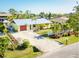 Charming yellow home featuring a well-manicured lawn, a driveway, and mature landscaping at 9031 Hilolo Ln, Venice, FL 34293