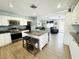 Bright kitchen featuring white cabinets, stainless steel appliances, granite countertops, and open to the living area at 9031 Hilolo Ln, Venice, FL 34293