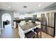Contemporary kitchen with white cabinets, granite countertops, stainless steel appliances, and a central island at 9031 Hilolo Ln, Venice, FL 34293