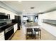 Bright, open-concept kitchen with white cabinets, stainless steel appliances, granite countertops, and an island at 9031 Hilolo Ln, Venice, FL 34293