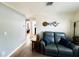 Cozy living room featuring wood floors and comfortable seating, with a glimpse into an adjacent bedroom at 9031 Hilolo Ln, Venice, FL 34293