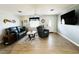 Well-lit living room featuring neutral walls, wood floors, comfortable furniture, and a view of the front door at 9031 Hilolo Ln, Venice, FL 34293