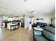 Spacious living room featuring wood floors, a kitchen view with stainless steel appliances, and comfortable seating at 9031 Hilolo Ln, Venice, FL 34293