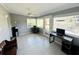 Inviting sunroom featuring tiled floors, a ceiling fan, and access to the backyard at 9031 Hilolo Ln, Venice, FL 34293