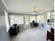 Bright sunroom with tile floors, ceiling fan, and views of the canal at 9031 Hilolo Ln, Venice, FL 34293
