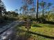Trail signage indicating 'Slash Pine Trail' and 'Myakka River Campsite' surrounded by forest on a clear day at 9031 Hilolo Ln, Venice, FL 34293