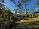 Serene nature trail with marked signs, lush vegetation, and tall trees leading to an information kiosk at 9031 Hilolo Ln, Venice, FL 34293