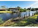 Tranquil waterfront view with a dock, lush greenery, and clear skies at 9031 Hilolo Ln, Venice, FL 34293