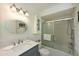 Bathroom featuring a glass enclosed tub, storage cabinet, and modern sink and mirror at 9414 Andover Cir, Bradenton, FL 34210