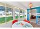 Dining area featuring a white table, red chairs, and views to the tennis court at 9414 Andover Cir, Bradenton, FL 34210