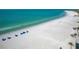 Stunning aerial view of a beach with blue umbrellas and calm waters at 1001 Benjamin Franklin Dr # 511, Sarasota, FL 34236