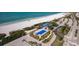 Breathtaking aerial view showcases pristine beach, aqua waters, pool and buildings, offering a stunning coastal panorama at 1001 Benjamin Franklin Dr # 511, Sarasota, FL 34236