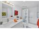 Bright bathroom with white vanity, floral art, and shower with blue floral curtain at 1001 Benjamin Franklin Dr # 511, Sarasota, FL 34236