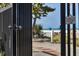 Gated entrance with signage offers a glimpse of the beach, landscaping, and bright blue umbrellas at 1001 Benjamin Franklin Dr # 511, Sarasota, FL 34236