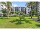 Lido Towers condo complex with lush landscaping, palm trees, and well-maintained grounds on a sunny day at 1001 Benjamin Franklin Dr # 511, Sarasota, FL 34236