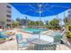 Enjoy sunny days poolside with tables, umbrellas, and loungers surrounded by tropical landscaping at 1001 Benjamin Franklin Dr # 511, Sarasota, FL 34236