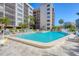 The large pool is surrounded by ample seating, palm trees, and manicured landscaping at 1001 Benjamin Franklin Dr # 511, Sarasota, FL 34236