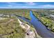 Stunning aerial view of a waterway with lush mangroves and a home nestled amongst the serene Florida landscape at 1284 Sorrento Woods Blvd, Nokomis, FL 34275