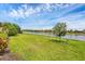 Spacious backyard with lush green lawn and a serene lake view, enhancing the property's appeal at 1290 Cielo Ct, North Venice, FL 34275