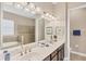 Bathroom featuring double sink vanity, large mirror, and soaking tub with tile surround and glass-enclosed shower at 1290 Cielo Ct, North Venice, FL 34275