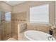Bright bathroom showcasing a glass shower, soaking tub, and window with natural light at 1290 Cielo Ct, North Venice, FL 34275