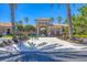 Community clubhouse entrance featuring a lovely facade and well maintained landscaping, surrounded by palm trees at 1290 Cielo Ct, North Venice, FL 34275