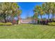 Attractive community entrance with landscaped grounds, a decorative sign, and lush tropical foliage at 1290 Cielo Ct, North Venice, FL 34275
