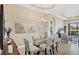 Dining room features a glass table, neutral walls, modern art, and chandelier lighting at 1290 Cielo Ct, North Venice, FL 34275