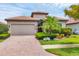 Charming single-story home with a brick paver driveway and well-manicured tropical landscaping at 1290 Cielo Ct, North Venice, FL 34275