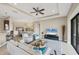 Bright, airy living room featuring tray ceilings, ceiling fan, and sliding glass doors at 1290 Cielo Ct, North Venice, FL 34275