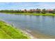 Peaceful waterfront property with serene pond view and verdant shoreline landscaping, enhancing curb appeal at 1290 Cielo Ct, North Venice, FL 34275