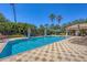 Inviting community pool area with lounge chairs, a covered seating area, and mature tropical landscaping providing shade at 1290 Cielo Ct, North Venice, FL 34275