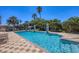Sparkling community pool surrounded by lounge chairs and lush tropical landscaping, with clear blue water at 1290 Cielo Ct, North Venice, FL 34275