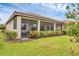 Enclosed screened patio offers outdoor living space, adjacent to a well-manicured lawn and lush garden landscape at 1290 Cielo Ct, North Venice, FL 34275
