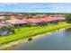 Picturesque water view featuring homes with tile roofs, enclosed lanais, and manicured lawns at 1290 Cielo Ct, North Venice, FL 34275