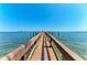 A long wooden dock stretches out to the ocean with clear blue skies above, inviting boaters to explore the open water at 1325 Gulf Dr N # 247, Bradenton Beach, FL 34217