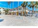 The front view of the resort building shows its parking spots, pedestrian walkway, and beach front access at 1325 Gulf Dr N # 247, Bradenton Beach, FL 34217
