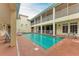 A courtyard pool surrounded by residential balconies and a small fountain, creating a private outdoor experience at 1325 Gulf Dr N # 247, Bradenton Beach, FL 34217