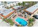 Aerial view of a community pool with lounge chairs and a brick deck surrounded by resort buildings with balconies at 1325 Gulf Dr N # 247, Bradenton Beach, FL 34217