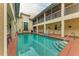 Courtyard pool with tanning deck, a small fountain and seating, all surrounded by residential balconies at 1325 Gulf Dr N # 247, Bradenton Beach, FL 34217