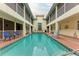 A courtyard pool surrounded by residential balconies and a small fountain, creating a private outdoor experience at 1325 Gulf Dr N # 247, Bradenton Beach, FL 34217