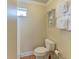 Compact bathroom with a toilet, small window, and decorative shelving unit at 1325 Gulf Dr N # 248, Bradenton Beach, FL 34217